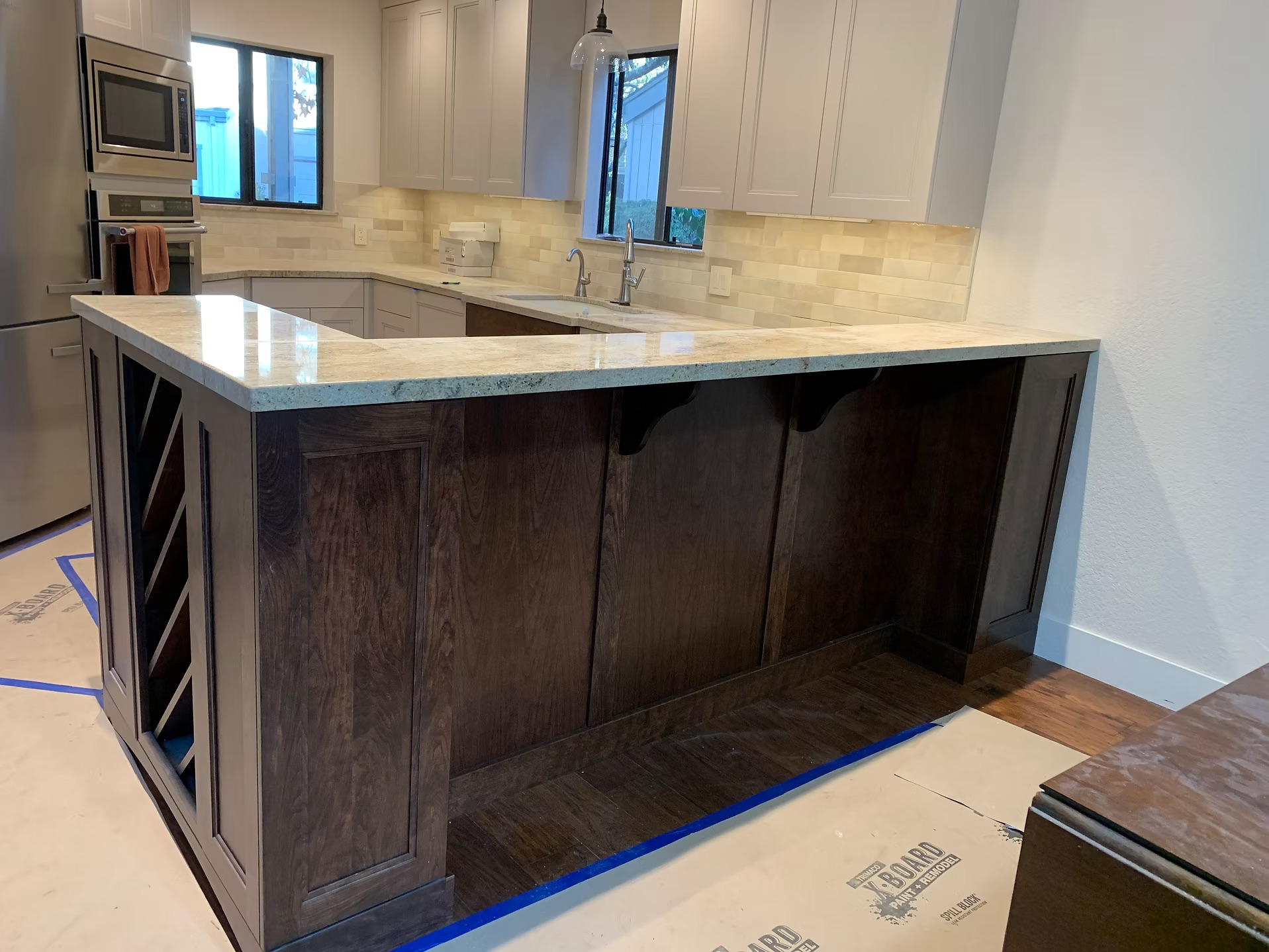 Stained wood kitchen island with granite countertop in remodeled kitchen