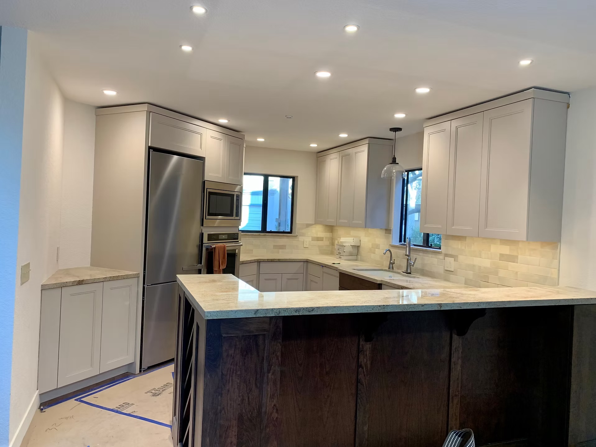 Gray shaker cabinets and light stone countertops in remodeled kitchen