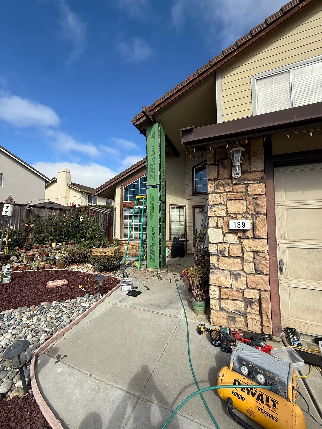 Stone veneer entry and house exterior with weather barrier installed on accent wall