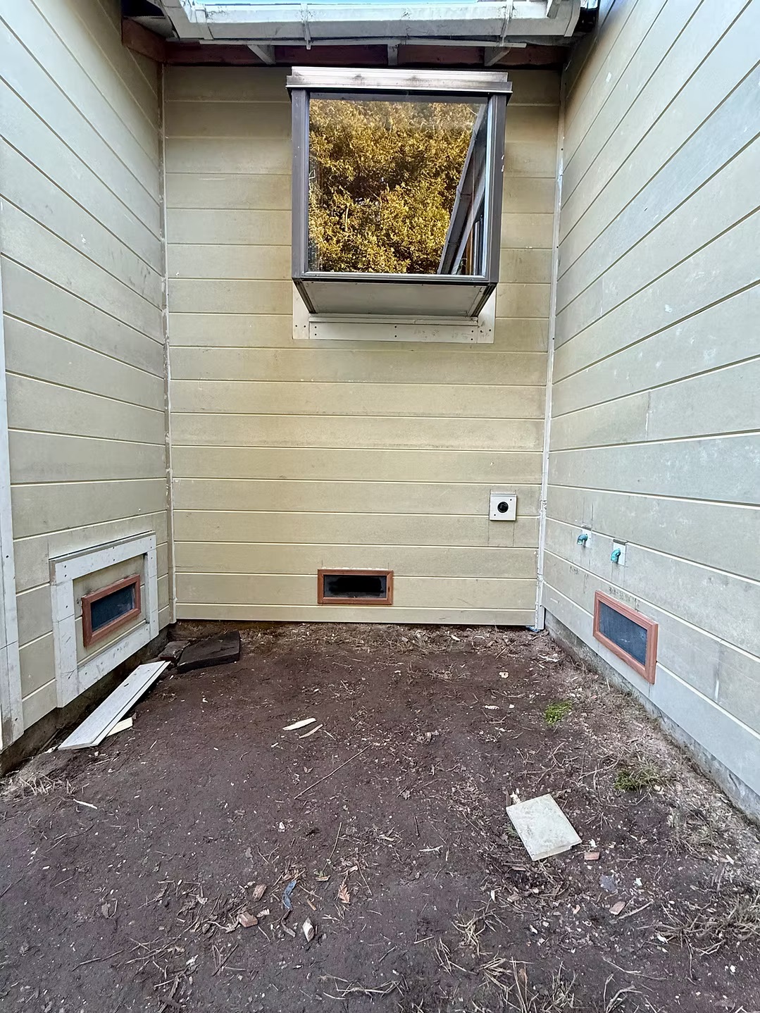 Finished tan lap siding with vent covers on home exterior corner
